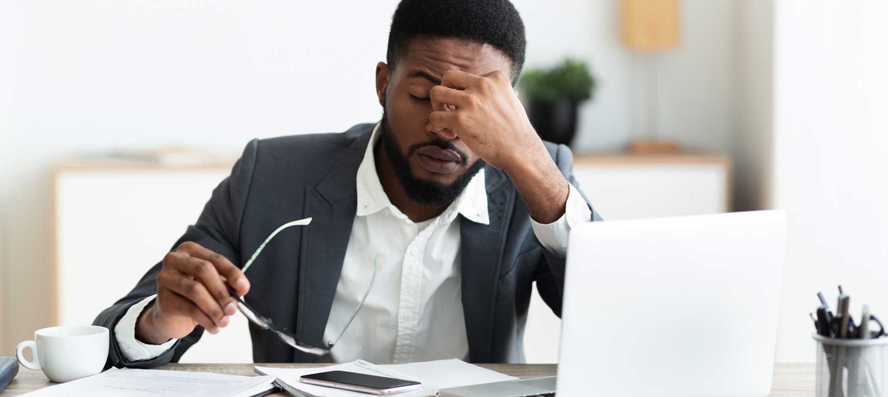 Professionista stressato seduto davanti a un computer portatile